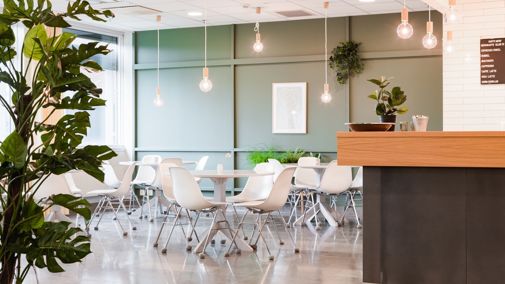 Två träd. stplar och bord i kontorsfastigheten Bricks 