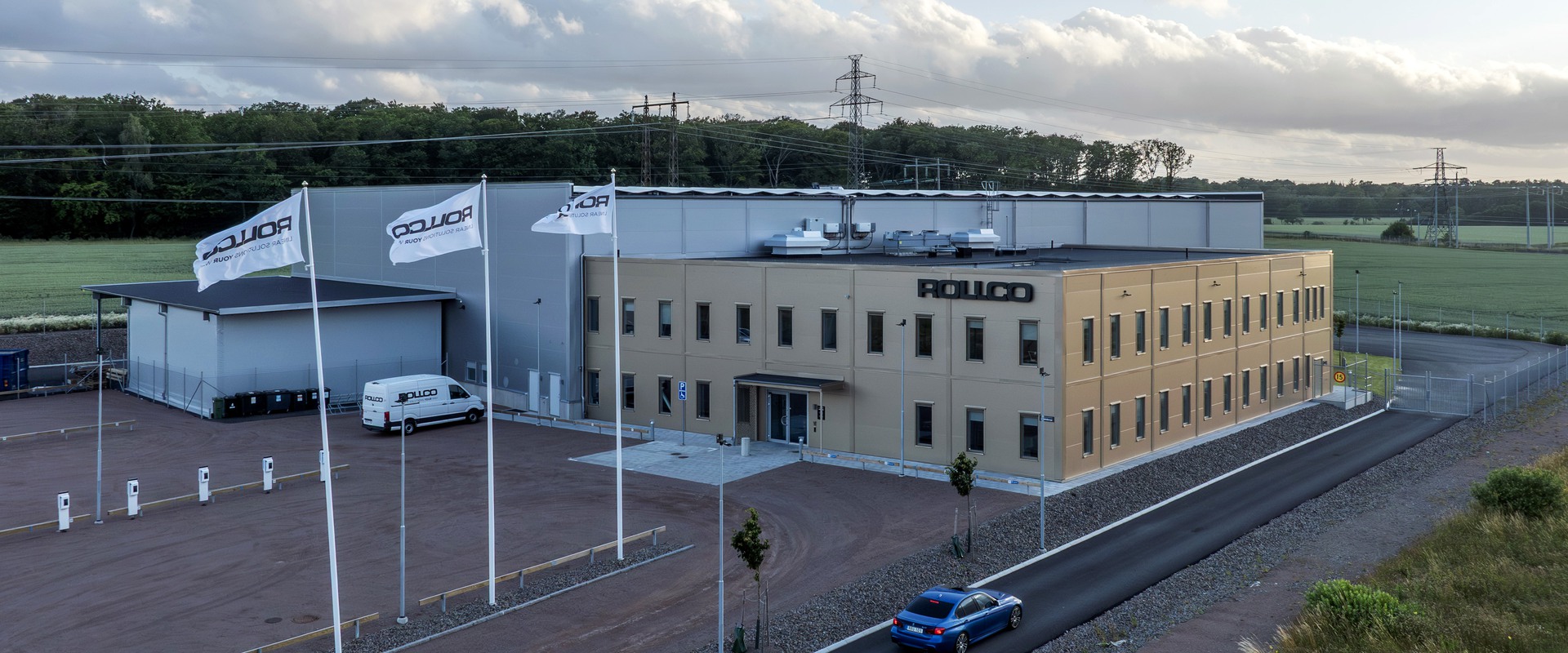 Den färdiga anläggningen. Rollco loggan på fasaden, solceller på taket och gräs utanför