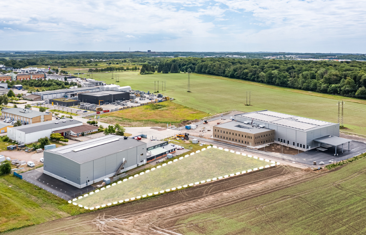 Illustration av en lagerlokal i rostfärg med staket som omgårdar området.