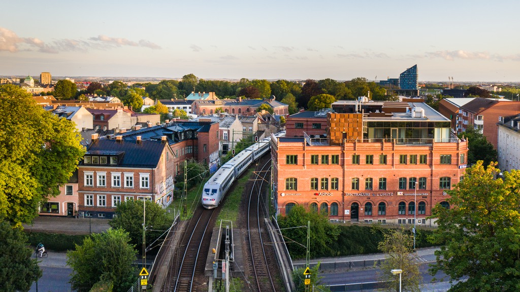 Fastighet i skymning när ett tåg åker förbi