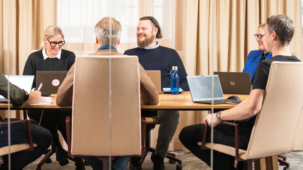 Glada personer som sitter i ett mötesrum