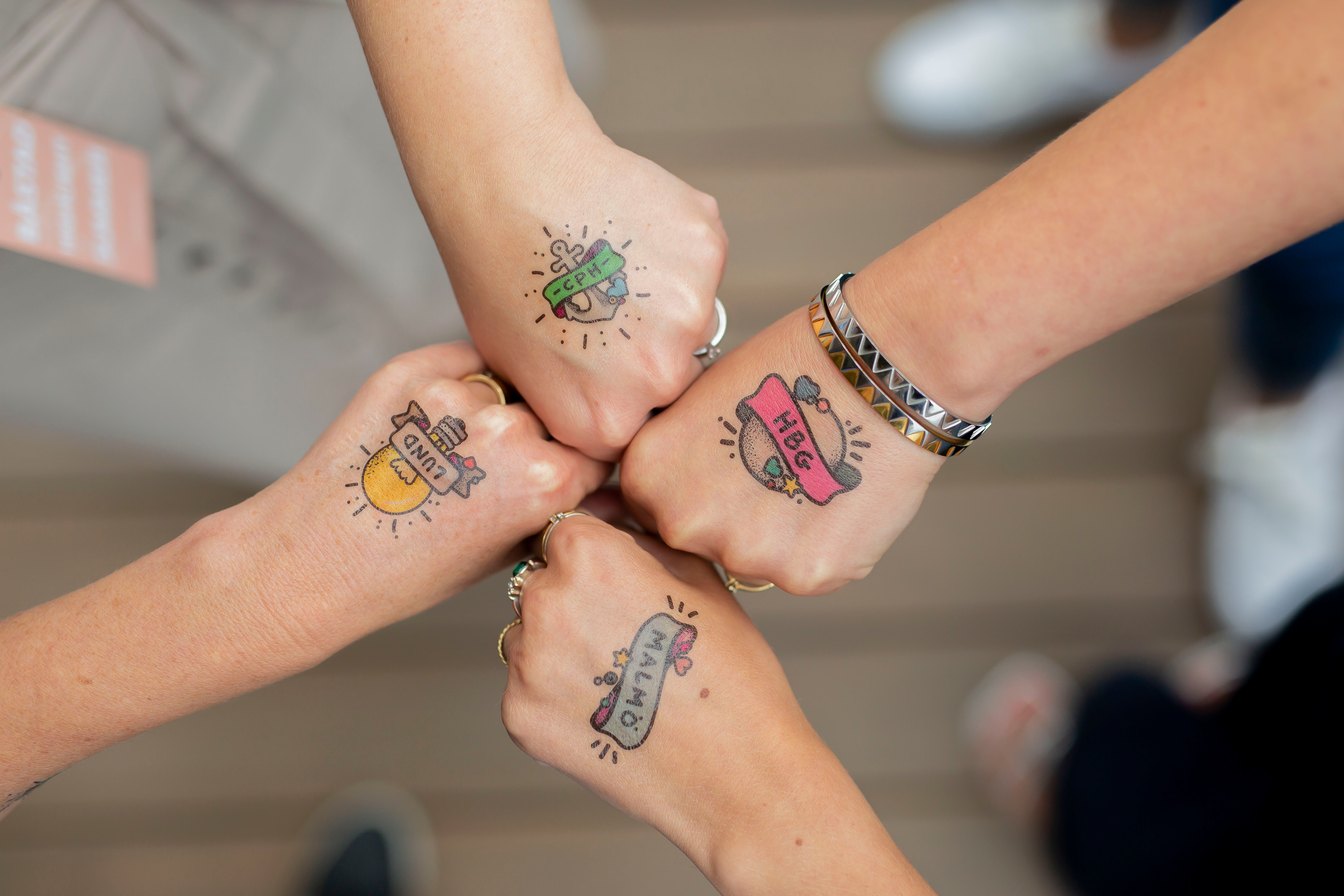 Fyra händer med fusktatueringar: Malmö, Lund, HBG, CPH.