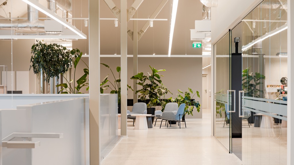 Träfärgad kontorsyta med kontorsstolar och bord 