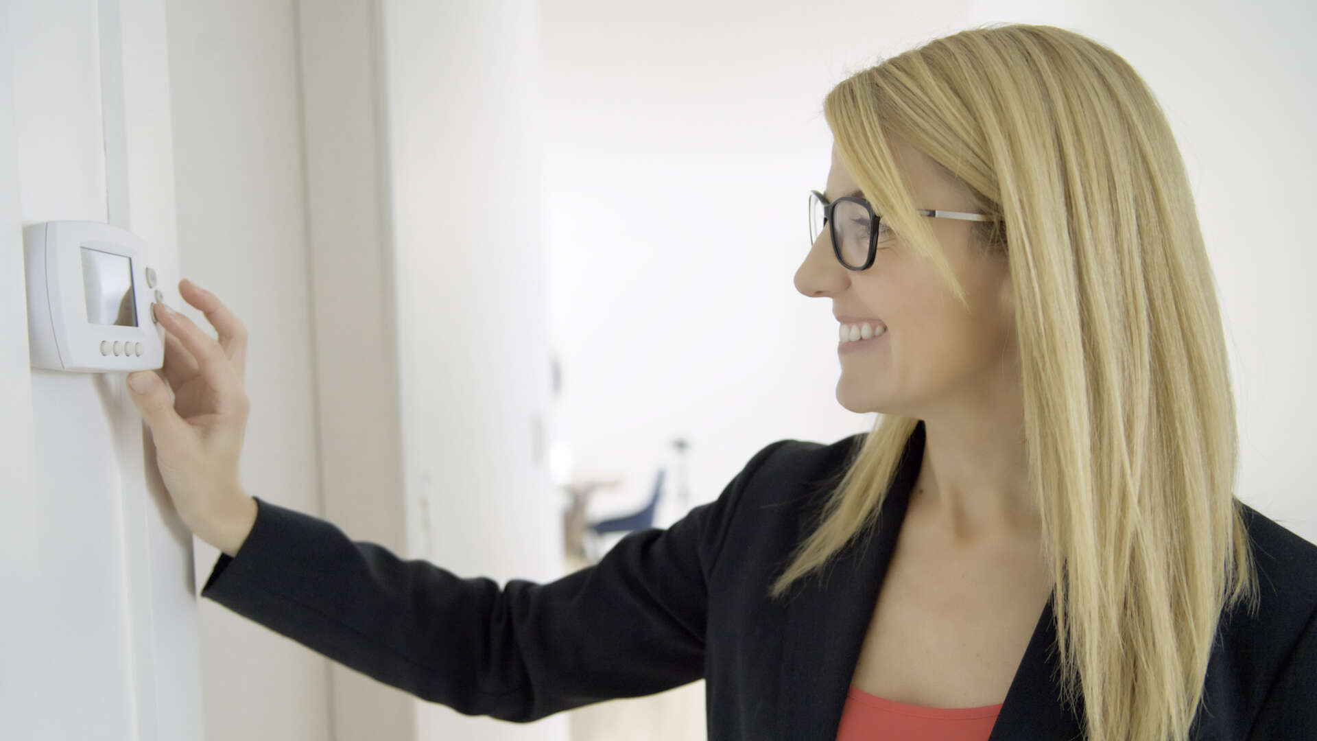 En kvinna ändrar inställningarna på en termostat.