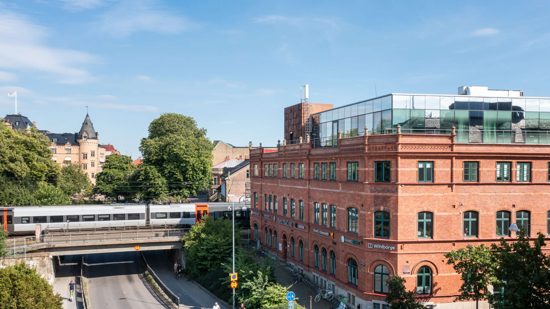 Ett tåg passerar bakom fastigheten Armaturen i centrala Lund.