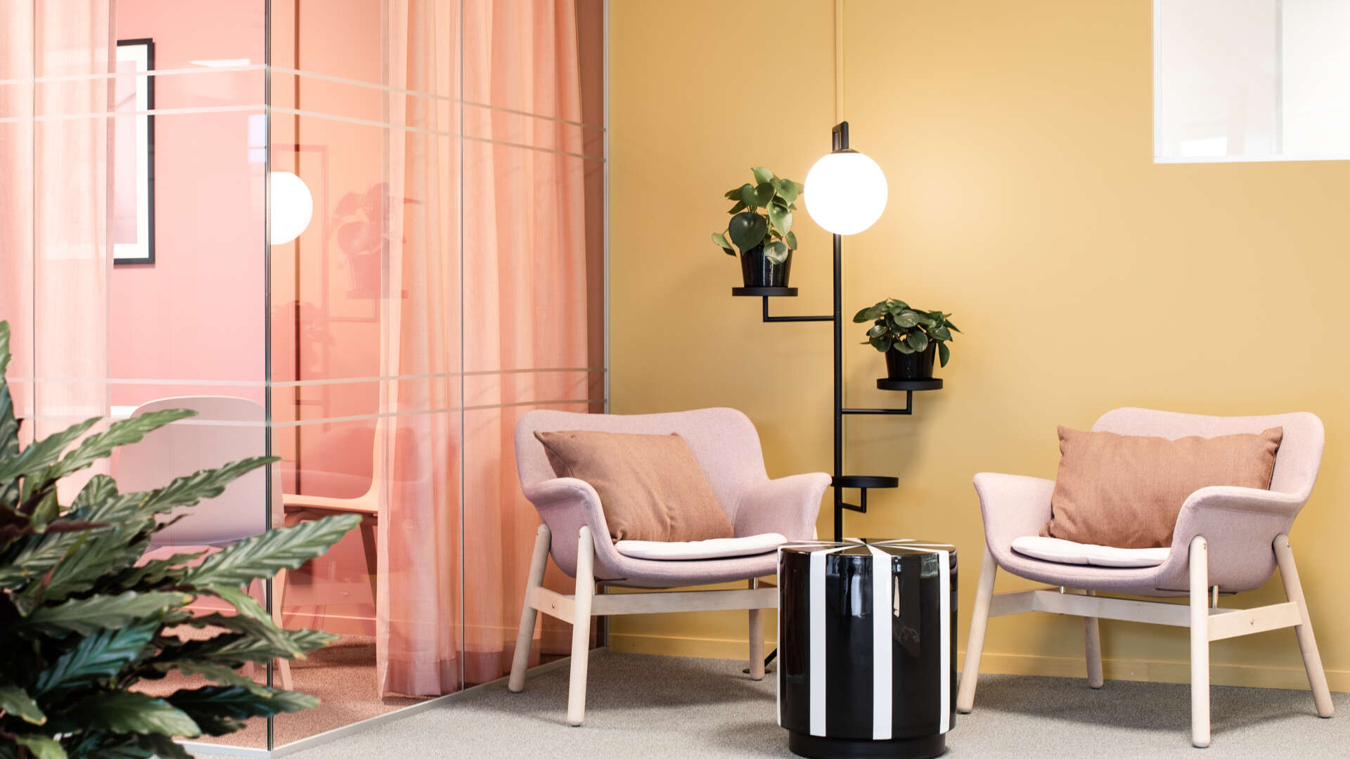 Två rosa fåtöljer i en hörna. 