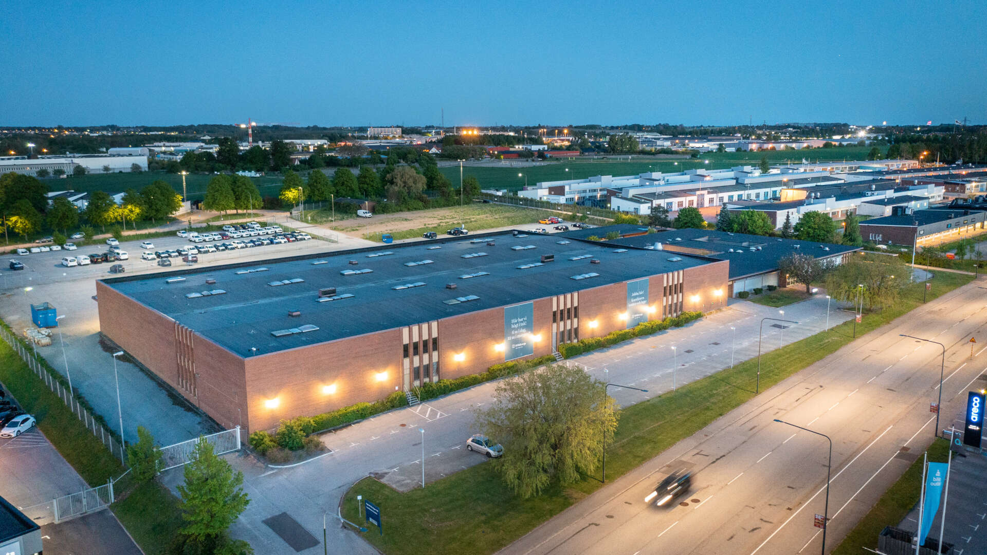 Flygbild av fastigheten Spännbucklan med omgivande parkeringsytor.